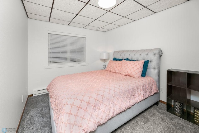 carpeted bedroom with a baseboard radiator and a paneled ceiling