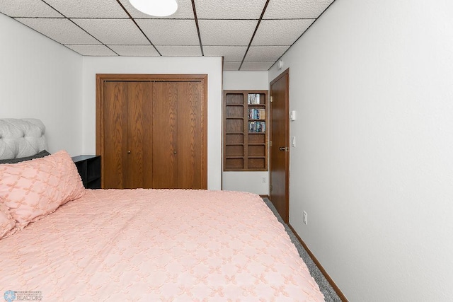 bedroom with a closet and a paneled ceiling