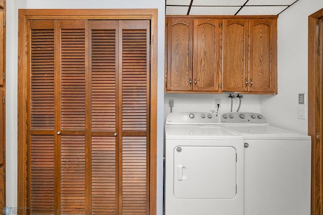 laundry room featuring washer and clothes dryer and cabinets