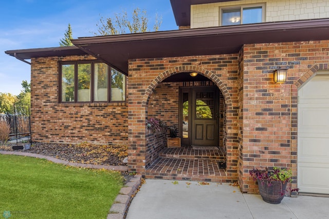 entrance to property featuring a lawn and a garage