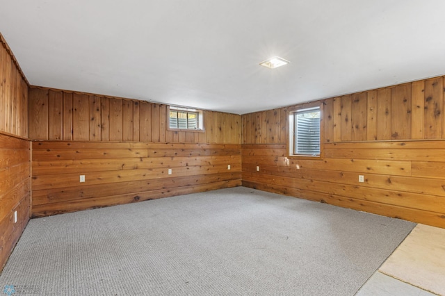 unfurnished room featuring wooden walls and light colored carpet