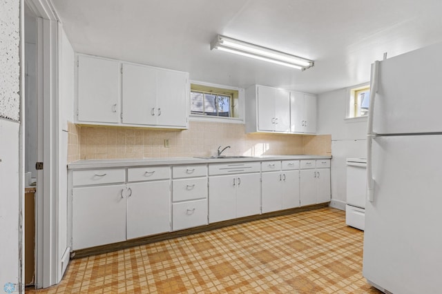 kitchen with white cabinetry, tasteful backsplash, sink, and white refrigerator