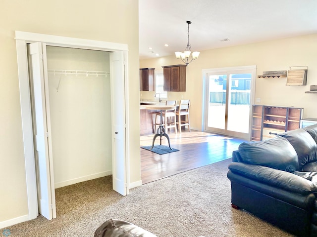 living room featuring an inviting chandelier, hardwood / wood-style flooring, and sink