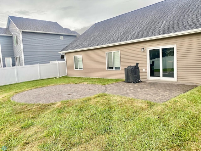 back of property with a yard and a patio area