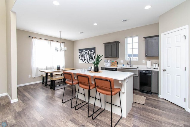 kitchen with a center island, a notable chandelier, gray cabinetry, and dark hardwood / wood-style flooring