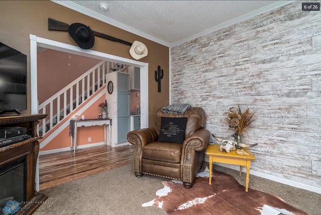 living area with ornamental molding, a textured ceiling, and wood-type flooring