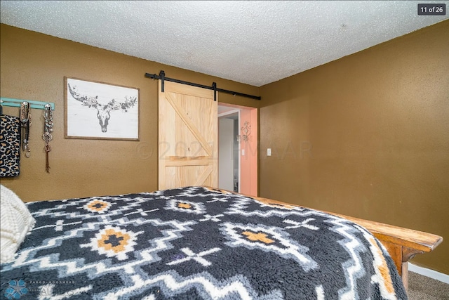 bedroom with a textured ceiling and a barn door