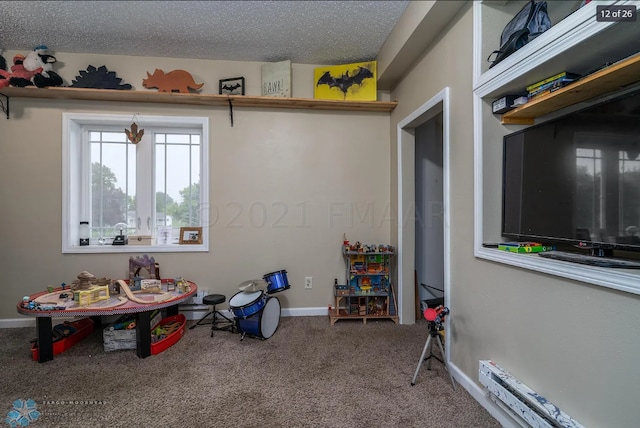 recreation room featuring a textured ceiling and carpet floors