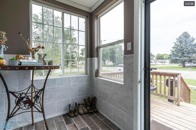 doorway with wood-type flooring and tile walls