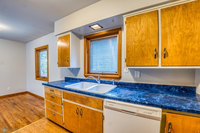 kitchen featuring white dishwasher, sink, and light wood-type flooring