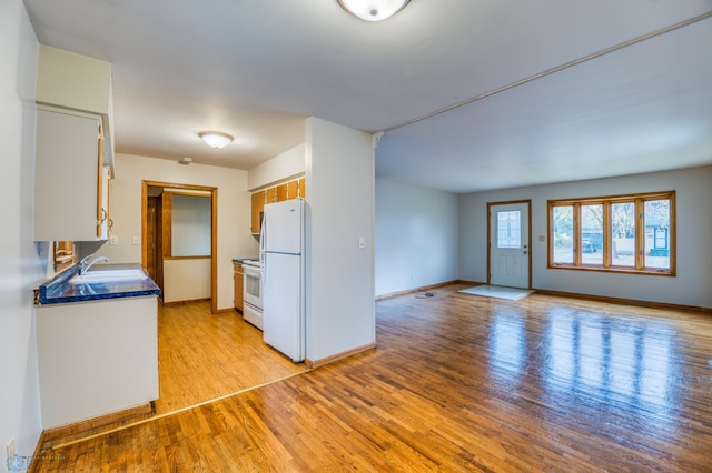 kitchen with white appliances, light hardwood / wood-style floors, and sink