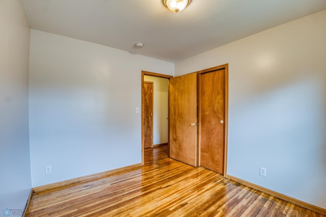 unfurnished bedroom featuring a closet and light wood-type flooring