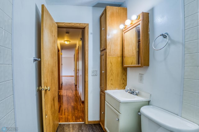 bathroom with vanity, toilet, and wood-type flooring