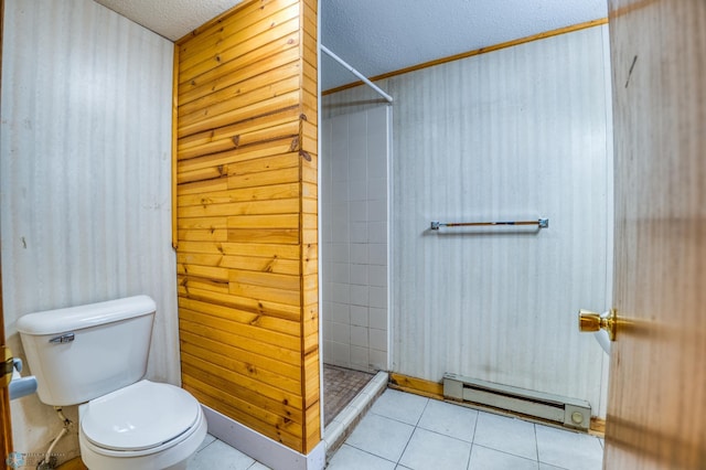 bathroom with a tile shower, a baseboard heating unit, a textured ceiling, toilet, and tile patterned flooring