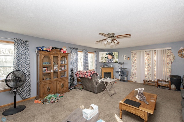 carpeted living room featuring a textured ceiling, a healthy amount of sunlight, and ceiling fan