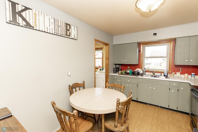 kitchen with light parquet floors, washer / clothes dryer, and sink