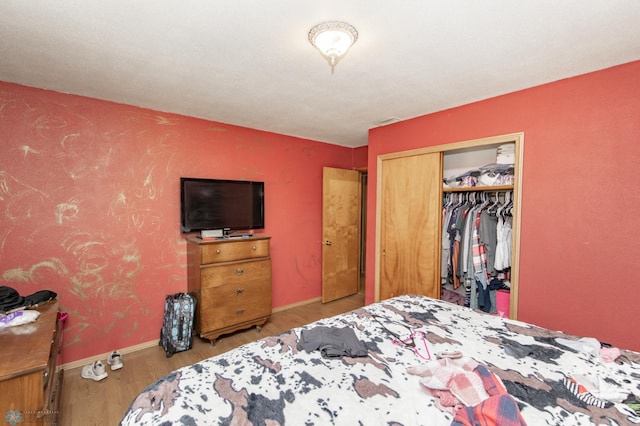 bedroom with light hardwood / wood-style floors and a closet