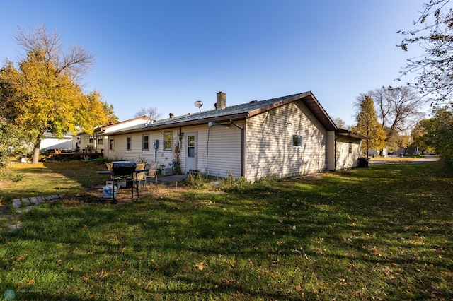 back of property featuring a yard