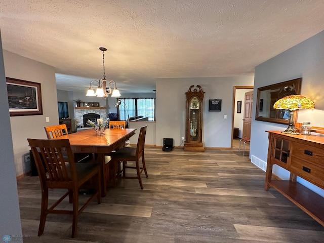 dining room with a notable chandelier, a textured ceiling, and wood-type flooring