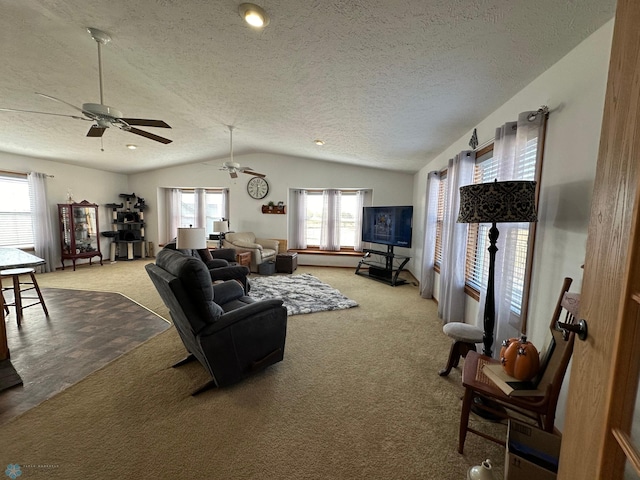 carpeted living room featuring ceiling fan, a textured ceiling, lofted ceiling, and plenty of natural light