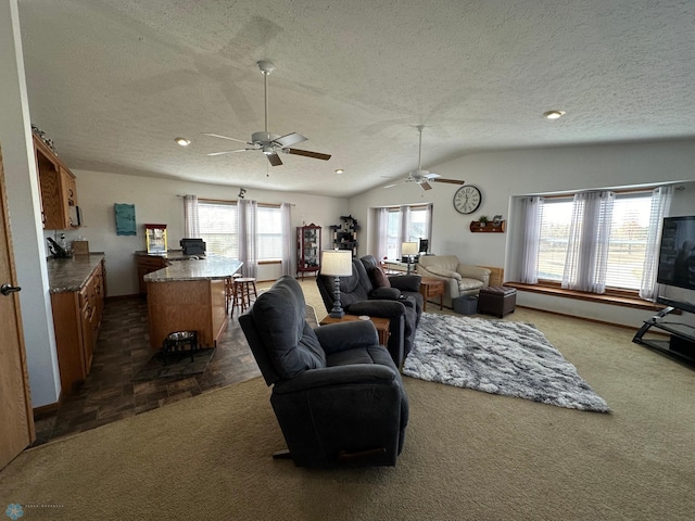 living room with a textured ceiling, ceiling fan, dark carpet, and vaulted ceiling