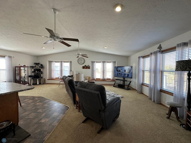 living room featuring ceiling fan, a textured ceiling, lofted ceiling, and light colored carpet