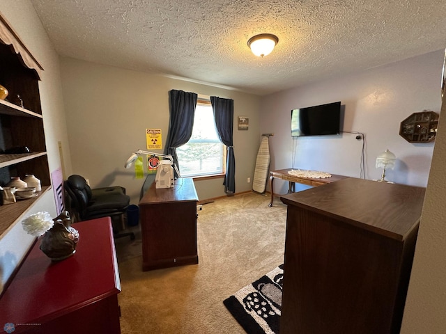 carpeted home office featuring a textured ceiling