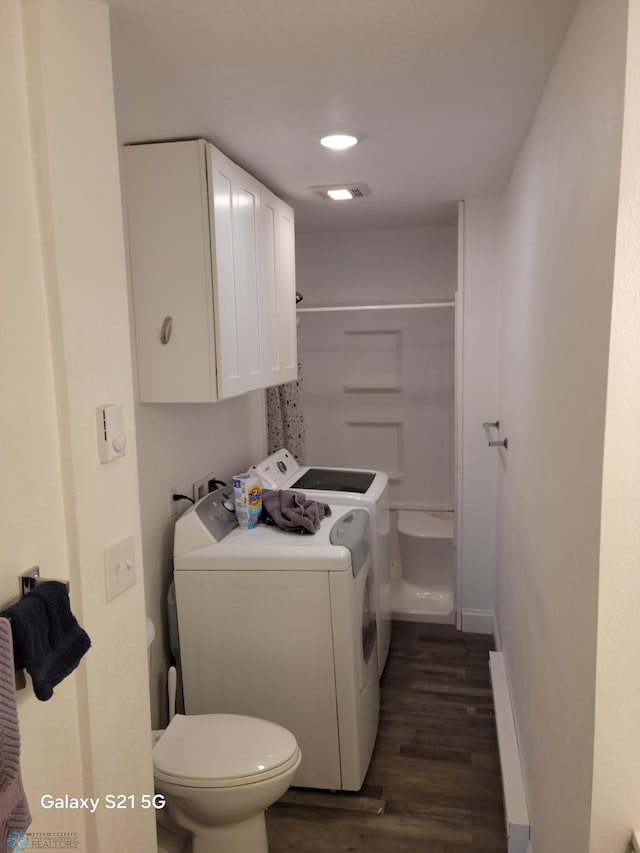 clothes washing area featuring washing machine and dryer and dark hardwood / wood-style flooring