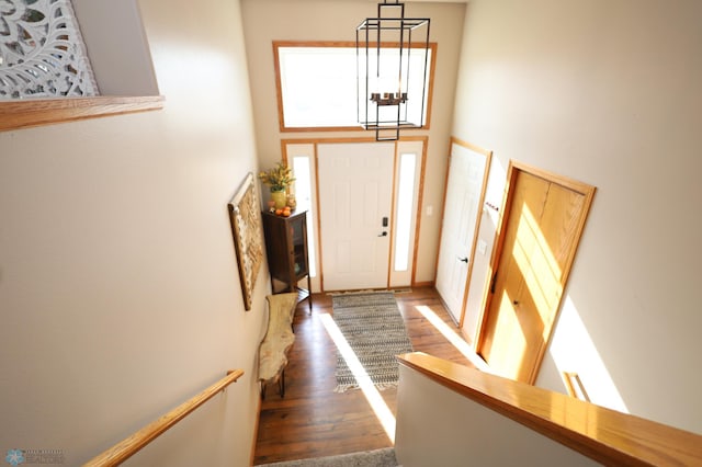 entryway featuring dark wood-type flooring and a notable chandelier