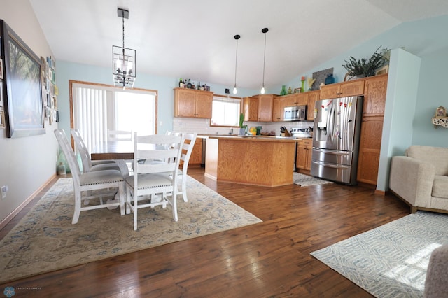 dining space with vaulted ceiling, a notable chandelier, and dark hardwood / wood-style flooring