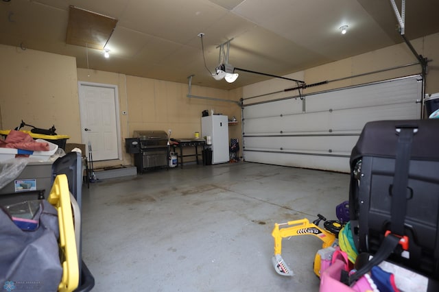 garage featuring a garage door opener and white fridge