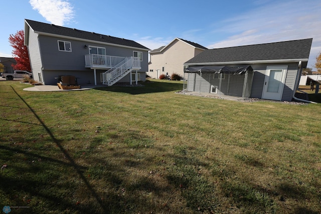 rear view of house featuring a yard and a deck