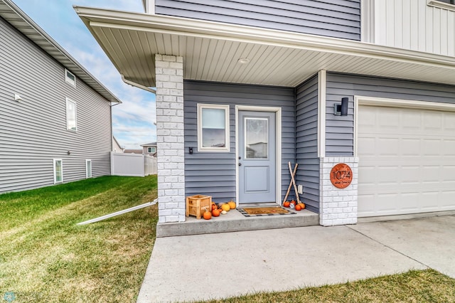 view of exterior entry featuring a yard and a garage