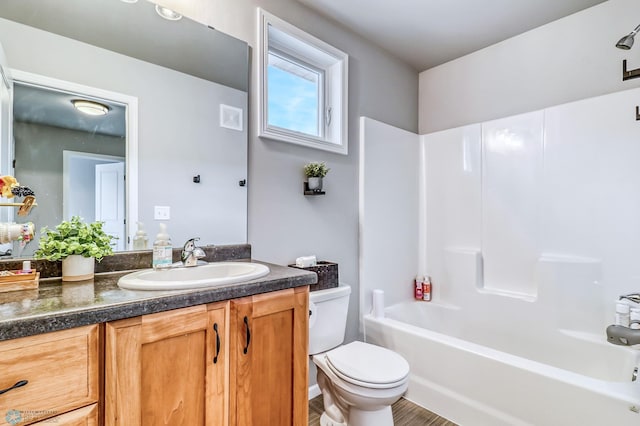 full bathroom featuring vanity, washtub / shower combination, hardwood / wood-style flooring, and toilet