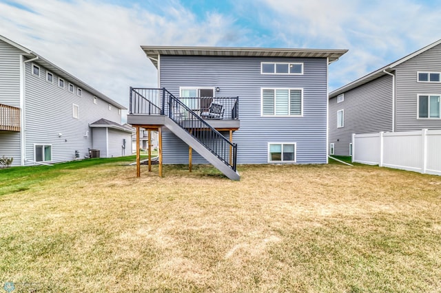 rear view of property with a wooden deck and a lawn