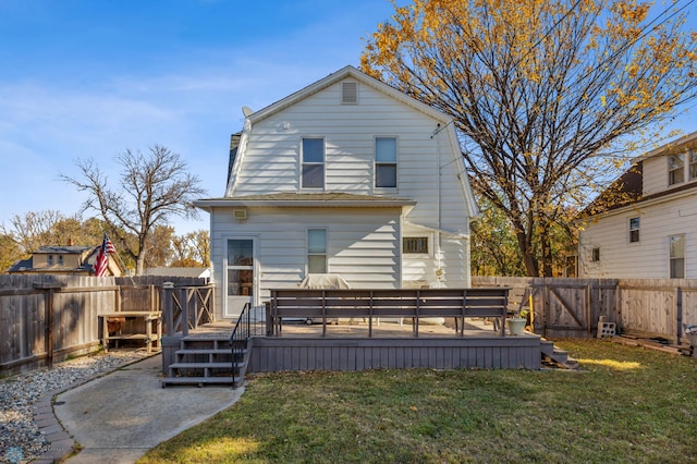 back of property featuring a wooden deck and a lawn