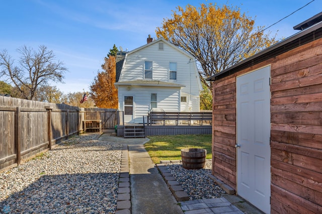 rear view of house featuring an outbuilding and a lawn