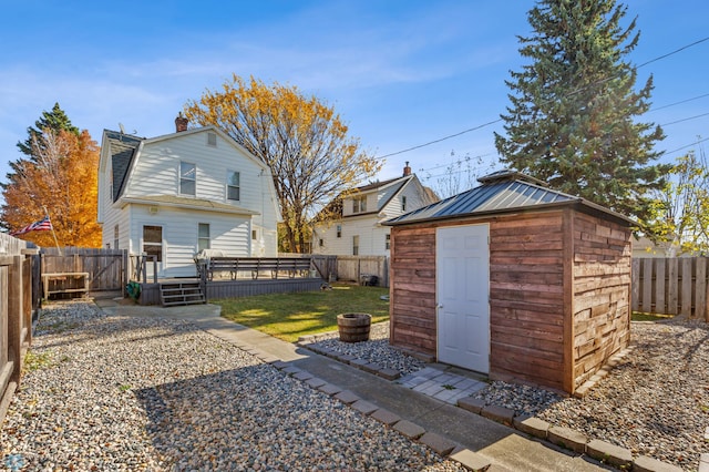 back of property with a storage shed and a lawn