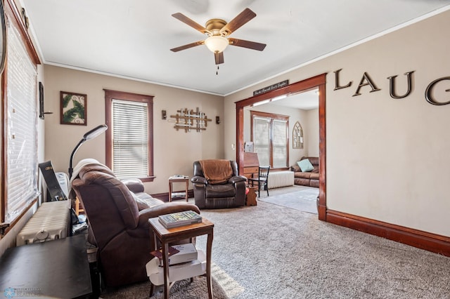 living room featuring ceiling fan, crown molding, and carpet