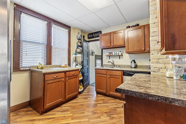 kitchen with light hardwood / wood-style floors, a paneled ceiling, stainless steel dishwasher, and sink