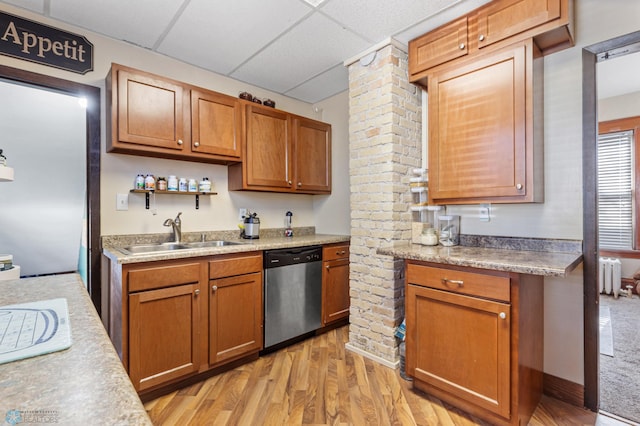 kitchen with a drop ceiling, light wood-type flooring, sink, radiator heating unit, and stainless steel dishwasher