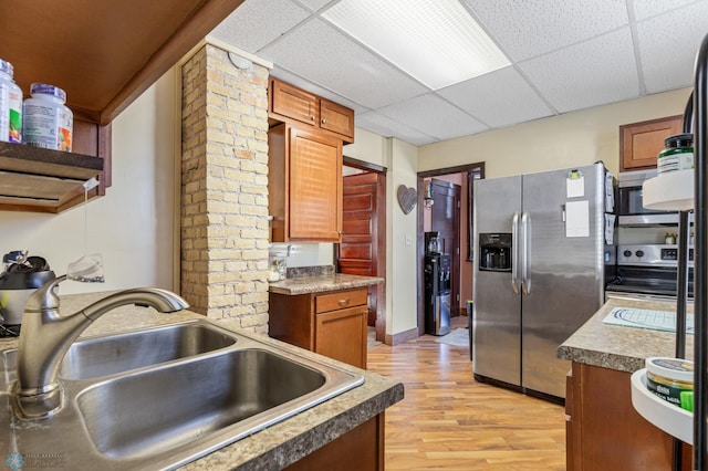 kitchen featuring appliances with stainless steel finishes, light hardwood / wood-style flooring, a paneled ceiling, and sink