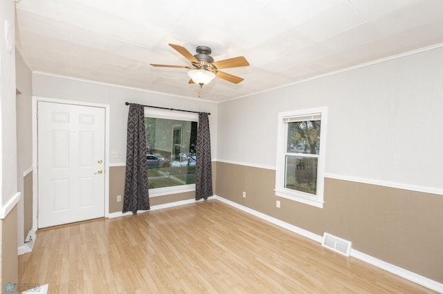 empty room with light hardwood / wood-style floors, ornamental molding, and ceiling fan