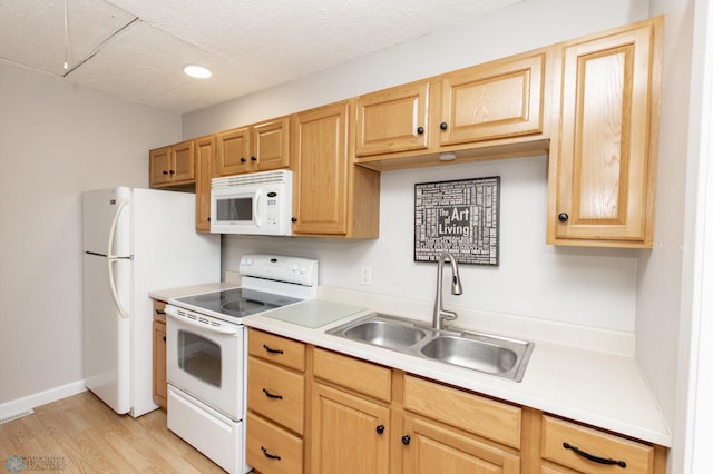 kitchen featuring light hardwood / wood-style floors, a textured ceiling, sink, and white appliances