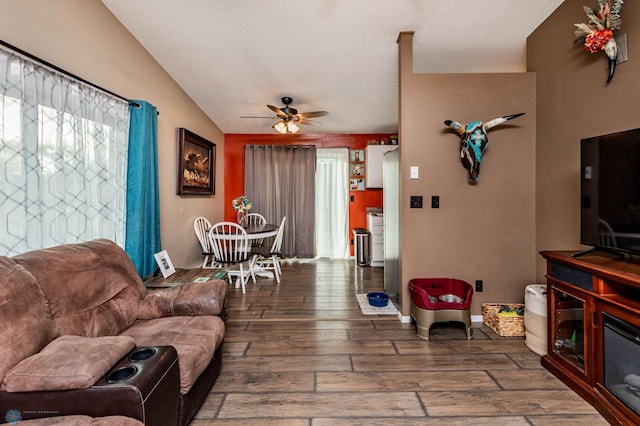 living room with lofted ceiling, ceiling fan, a textured ceiling, and dark hardwood / wood-style flooring