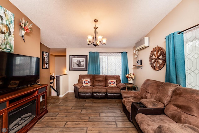 living room featuring a textured ceiling, a wall unit AC, dark hardwood / wood-style floors, and an inviting chandelier