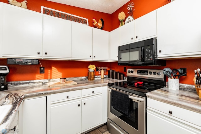 kitchen with stainless steel electric range, white cabinets, a textured ceiling, and hardwood / wood-style flooring