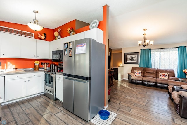 kitchen with stainless steel appliances, pendant lighting, and dark hardwood / wood-style floors