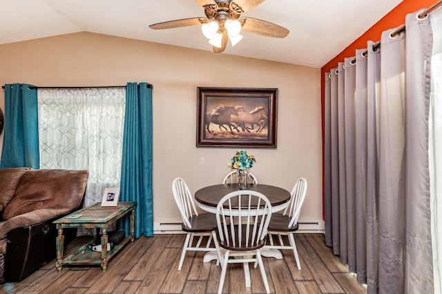 dining space featuring ceiling fan, vaulted ceiling, baseboard heating, and hardwood / wood-style floors