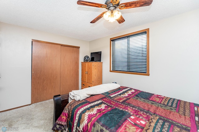 carpeted bedroom featuring a closet, a textured ceiling, and ceiling fan